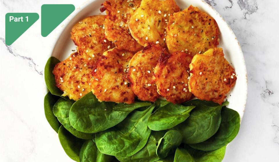 Golden-brown cauliflower fritters with fresh spinach on a plate
